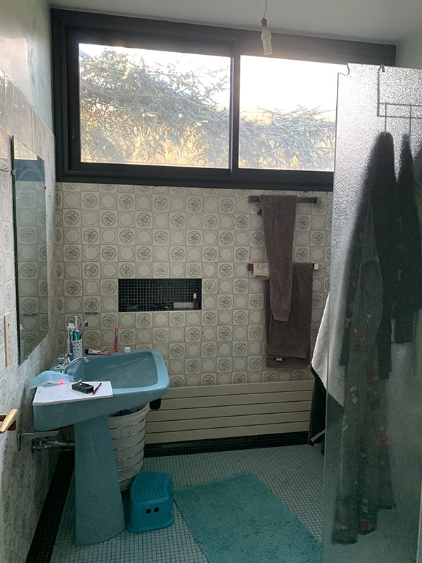 Ancienne salle d'eau des années 80 avec lavabo sur colonne bleu et carrelage vieillot avant travaux de rénovation par Home Feeling dans le Val d'Oise