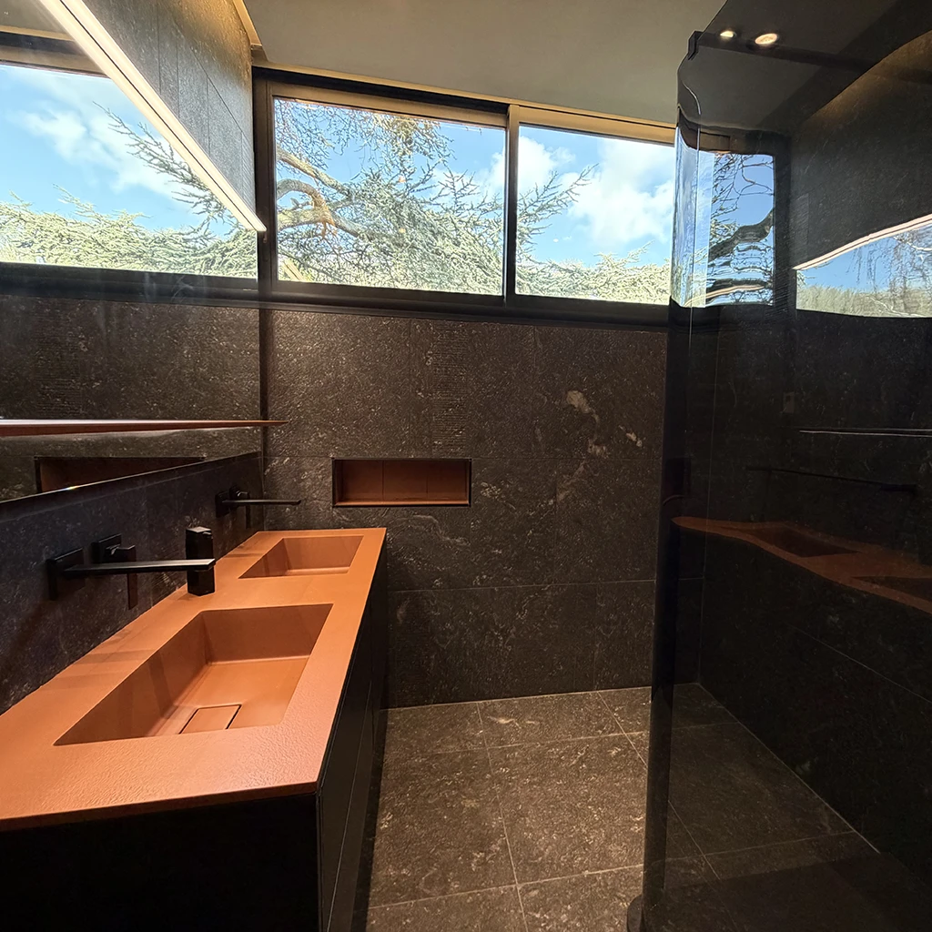 Relooking total par Home Feeling d'une salle d'eau moderne à Pontoise avec double vasque orange, robinetterie noire encastrée et carrelage gris foncé